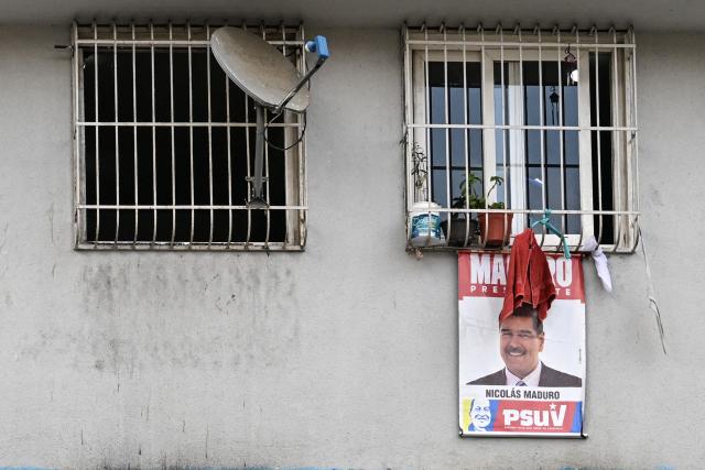 A campaign poster depicting ousted Venezuelan President Nicolas Maduro hangs from the windows of a state-built housing complex in Caracas on January 23, 2026. Thousands of Nicolas Maduro's supporters marched in Caracas on January 23, calling for the release of the ousted president, as Venezuela marked the 68th anniversary of the fall of military dictatorship. (Photo by Juan BARRETO / AFP)