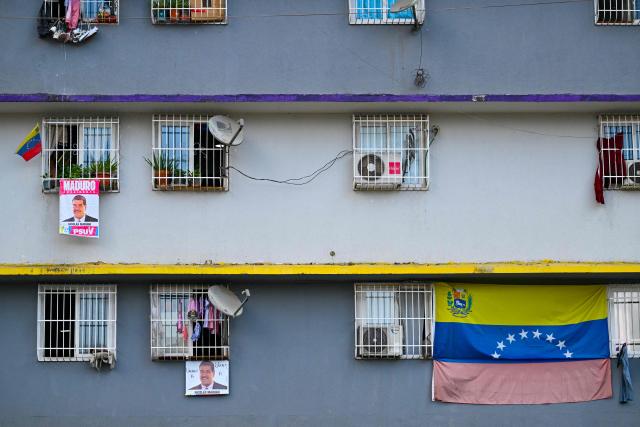 Campaign posters depicting ousted Venezuelan President Nicolas Maduro hang from the windows of a state-built housing complex in Caracas on January 23, 2026. Thousands of Nicolas Maduro's supporters marched in Caracas on January 23, calling for the release of the ousted president, as Venezuela marked the 68th anniversary of the fall of military dictatorship. (Photo by Juan BARRETO / AFP)