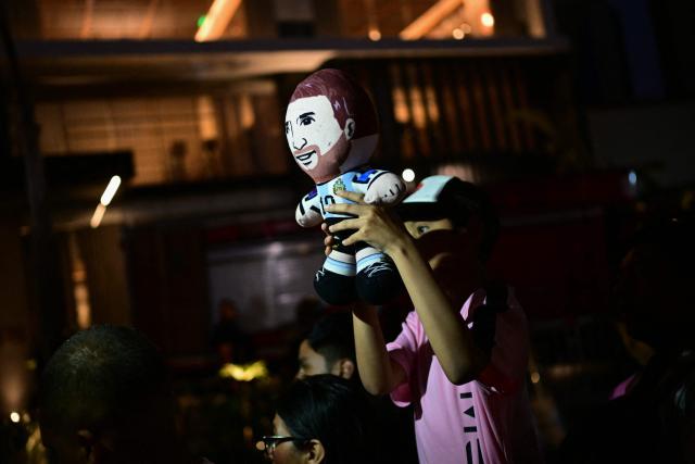 A fan wearing a jersey of the Inter Miami football team holds a toy depicting Argentine player Lionel Messi as he awaits the team's arrival outside the Hotel Intercontinental in Lima on January 23, 2025, on the eve of the friendly football match against Alianza Lima. (Photo by ERNESTO BENAVIDES / AFP)