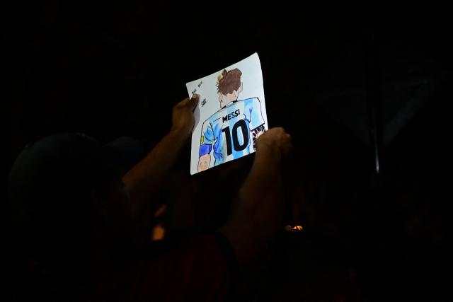 A fan holds a hand-drawn image depicting Inter Miami's Argentine player Lionel Messi as he awaits the team's arrival outside the Hotel Intercontinental in Lima on January 23, 2025, on the eve of the friendly football match against Alianza Lima. (Photo by ERNESTO BENAVIDES / AFP)