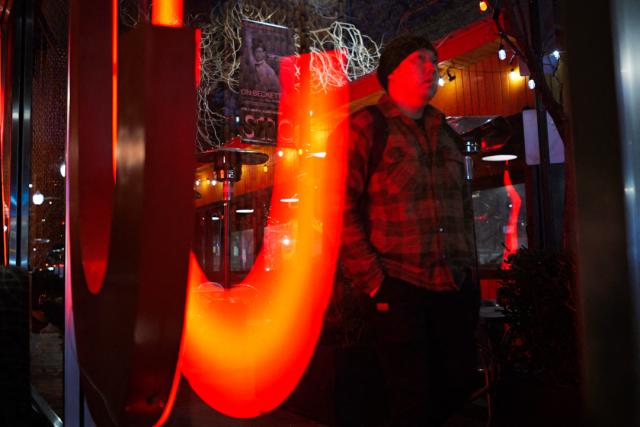 A person walks past a restaurant in Washington, DC on January 23, 2026. A massive storm system is set to drop a mix of freezing rain and heavy snow starting January 23 on its days-long march across the continental US. (Photo by Mandel NGAN / AFP)