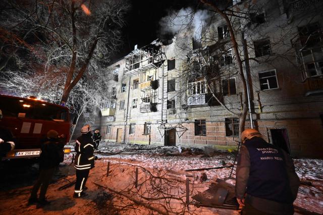 Ukrainian rescuers work at the site of a damaged  residential building following an air attack in Kharkiv on January 24, 2026, amid the Russian invasion of Ukraine. Russian strikes killed one person and injured at least 15 others in Ukraine's capital and the northeastern city of Kharkiv overnight, authorities said early on January 24. (Photo by SERGEY BOBOK / AFP)