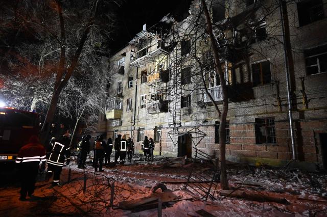 Ukrainian rescuers work at the site of a damaged  residential building following an air attack in Kharkiv on January 24, 2026, amid the Russian invasion of Ukraine. Russian strikes killed one person and injured at least 15 others in Ukraine's capital and the northeastern city of Kharkiv overnight, authorities said early on January 24. (Photo by SERGEY BOBOK / AFP)