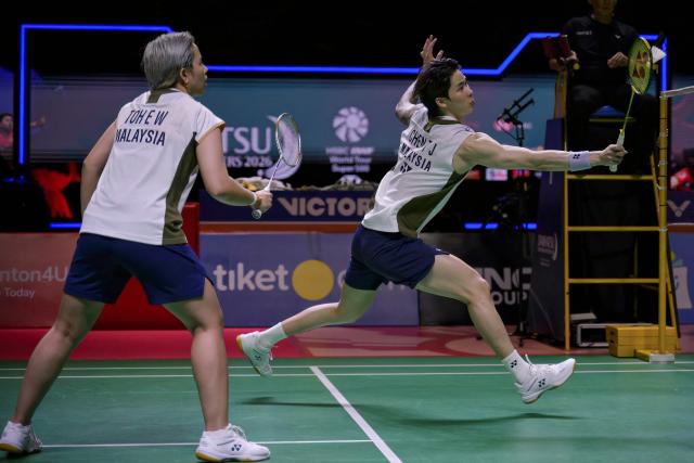 Malaysia’s Chen Tang Jie and Toh Ee Wei hit a return during their mixed doubles semifinal match against China's Jiang Zhenbang and Wei Yaxin at the Indonesia Masters badminton tournament in Jakarta on January 24, 2026. (Photo by BAY ISMOYO / AFP)