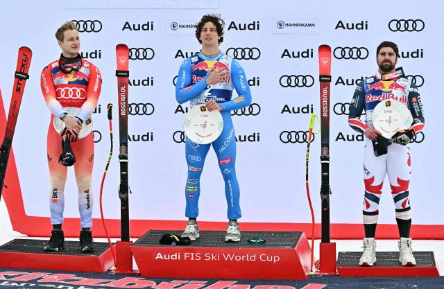 (L-R) Second placed Switzerland's Marco Odermatt, winner Italy's Giovanni Franzoni and third placed France's Maxence Muzaton celebrate on the podium after the Men's Downhill event of the FIS Alpine Skiing World Cup in Kitzbuhel, Austria, on January 24, 2026. (Photo by Joe Klamar / AFP)