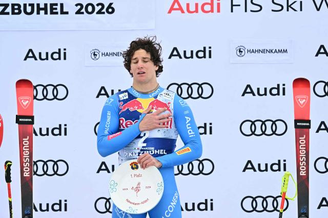 Winner Italy's Giovanni Franzoni celebrates on the podium with his trophy after the Men's Downhill event of the FIS Alpine Skiing World Cup in Kitzbuhel, Austria, on January 24, 2026. (Photo by Joe Klamar / AFP)