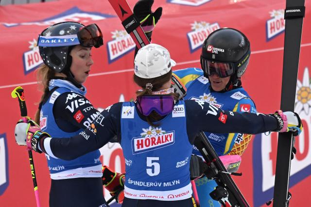 Winner Sweden's Sara Hector (R) celebrates with second-placed US' Paula Moltzan and third-placed US' Mikaela Shiffrin (L) in the finishing area after competing in the second run of the Women's Giant Slalom event of FIS Alpine Skiing World Cup in Spindleruv Mlyn on January 24, 2026. (Photo by Michal Cizek / AFP)