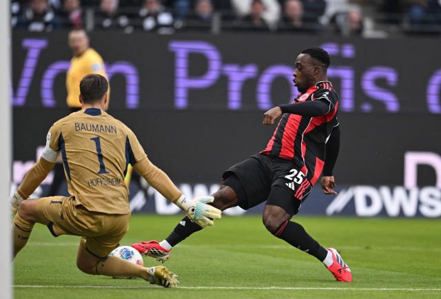 Hoffenheim's German goalkeeper #01 Oliver Baumann (L) and Frankfurt's French forward #25 Arnaud Kalimuendo vie for the ball during the German first division Bundesliga football match between Eintracht Frankfurt and TSG 1899 Hoffenheim in Frankfurt am Main, western Germany, on January 24, 2026. (Photo by Kirill KUDRYAVTSEV / AFP) / DFL REGULATIONS PROHIBIT ANY USE OF PHOTOGRAPHS AS IMAGE SEQUENCES AND/OR QUASI-VIDEO