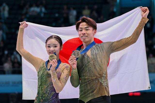 Japan's Yuna Nagaoka (L) and Sumitada Moriguchi celebrate with their medals after finishing third in the pairs competition at the ISU Four Continents Figure Skating Championships in Beijing on January 24, 2026. (Photo by GREG BAKER / AFP)