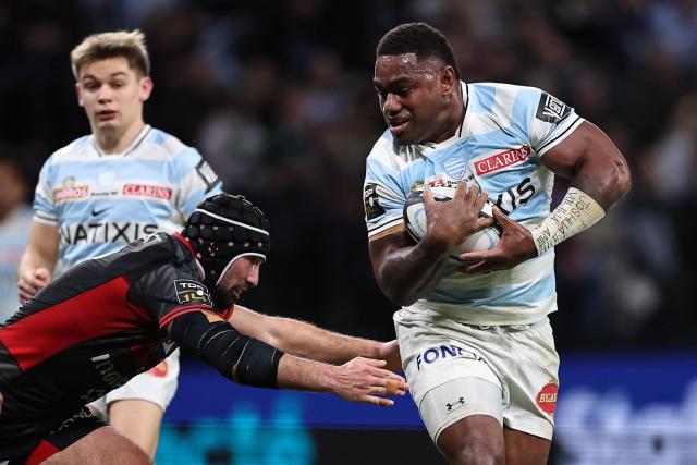 Racing 92' Fijian centre Josua Tuisova (R) runs to evade Lyon's French centre Theo Millet (L)  during the French Top14 rugby union match between Racing 92 and Lyon Olympique Universitaire Rugby (LOU) at the Paris La Defense Arena in Nanterre, on the outskirts of Paris on January 24, 2026. (Photo by Anne-Christine POUJOULAT / AFP)