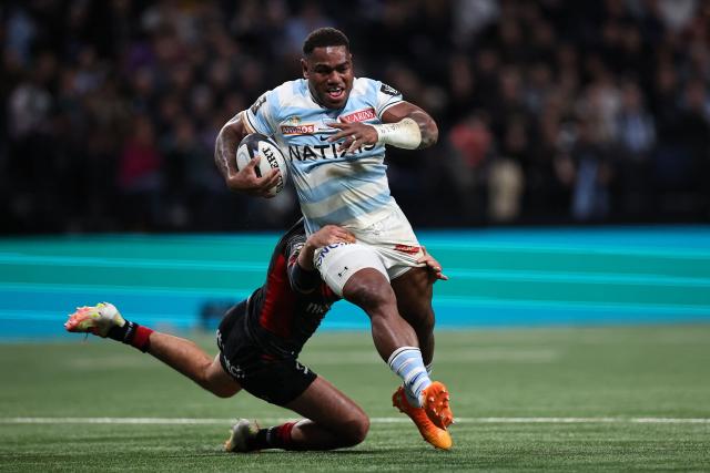Fiji’s Josua Racing 92' Fijian centre Josua Tuisova (R) runs to evade a tackle by Lyon's French centre Theo Millet  during the French Top14 rugby union match between Racing 92 and Lyon Olympique Universitaire Rugby (LOU) at the Paris La Defense Arena in Nanterre, on the outskirts of Paris on January 24, 2026. (Photo by Anne-Christine POUJOULAT / AFP)