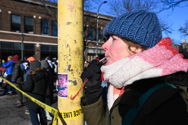 A woman blows a whistle as demonstrators gather near the site of where state and local authorities say a man was shot by federal agents earlier in the morning in Minneapolis, Minnesota, on January 24, 2026. Minnesota Governor Tim Walz said Saturday that federal agents deployed in Minneapolis as part of a sweeping immigration crackdown had carried out "another horrific shooting," less than three weeks after the fatal shooting of Renee Good. (Photo by ROBERTO SCHMIDT / AFP)