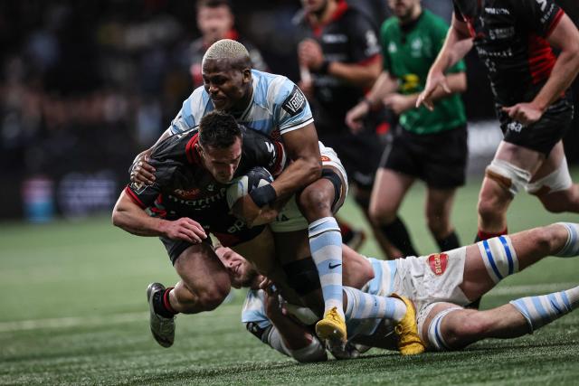 Lyon's French scrum-half Baptiste Couilloud (L) is tackled by Racing 92' South African flanker Hacjivah Dayimani  during the French Top14 rugby union match between Racing 92 and Lyon Olympique Universitaire Rugby (LOU) at the Paris La Defense Arena in Nanterre, on the outskirts of Paris on January 24, 2026. (Photo by Anne-Christine POUJOULAT / AFP)