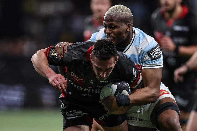 Lyon's French scrum-half Baptiste Couilloud (L) is tackled by Racing 92' South African flanker Hacjivah Dayimani  during the French Top14 rugby union match between Racing 92 and Lyon Olympique Universitaire Rugby (LOU) at the Paris La Defense Arena in Nanterre, on the outskirts of Paris on January 24, 2026. (Photo by Anne-Christine POUJOULAT / AFP)