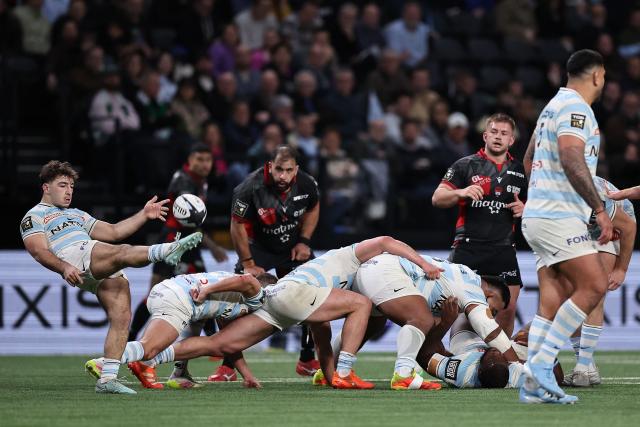 Racing 92' French scrum-half Leo Carbonneau (L) hits a box kick  during the French Top14 rugby union match between Racing 92 and Lyon Olympique Universitaire Rugby (LOU) at the Paris La Defense Arena in Nanterre, on the outskirts of Paris on January 24, 2026. (Photo by Anne-Christine POUJOULAT / AFP)