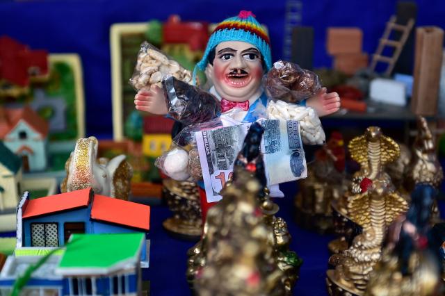 A toy representing Aymara god 'Ekeko' is displayed during the Alasitas indigenous festivity fair in La Paz on January 24, 2026. The festivity pays homage to the 'Ekeko' that according to the Andean tradition, provides earthly wealth and pleases the requests of its worshipers, who buy miniature goods representing their hopes for the coming year. (Photo by Jorge BERNAL / AFP)