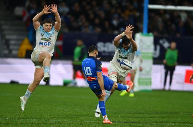 Castres's French fly-half Enzo Herve (C) kicks the ball as Bayonne's players attempt to charge it down during the French Top14 rugby union match between Aviron Bayonnais (Bayonne) and Castres Olympique at the Stade Jean Dauger in Bayonne, south-western France on January 24, 2026. (Photo by Gaizka IROZ / AFP)