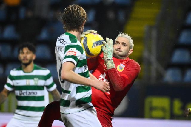 Arouca's Uruguayan goalkeeper #12 Ignacio De Arruabarrena (R) grabs the ball challenged by Sporting Lisbon's Danish midfielder #42 Morten Hjulmand during the Portuguese League football match between FC Arouca and Sporting CP at the Municipal de Arouca stadium in Aveiro on January 24, 2026. (Photo by Miguel RIOPA / AFP)