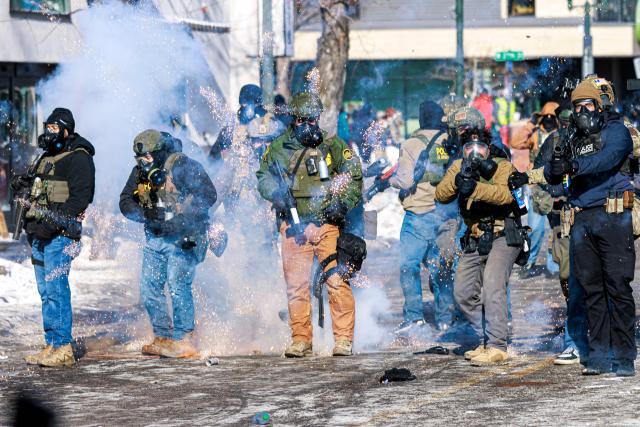 Federal agents fire flash-bang grenades as they advance toward protesters during clashes following the fatal shooting of a man by federal immigration agents earlier in the day, on January 24, 2026 in Minneapolis, Minnesota. Federal immigration agents shot dead a man in Minneapolis on Saturday, officials said -- the second fatal shooting of a civilian in the city, sparking fresh protests and outrage from state officials. The death came less than three weeks after US citizen Renee Good was shot and killed by an Immigration and Customs Enforcement officer involved in sweeps to round up undocumented migrants. (Photo by Kerem YUCEL / AFP)