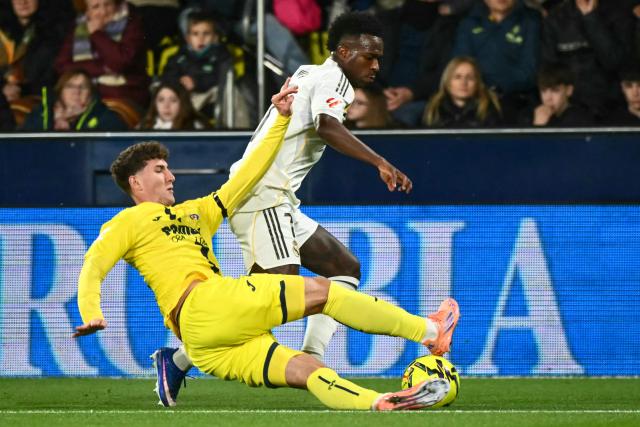 Real Madrid's Brazilian forward #07 Vinicius Junior (R) is challenged by Villarreal's Spanish defender #26 Pau Navarro during the Spanish league football match between Villarreal CF and Real Madrid CF at La Ceramica Stadium in Vila-Real on January 24, 2026. (Photo by JOSE JORDAN / AFP)