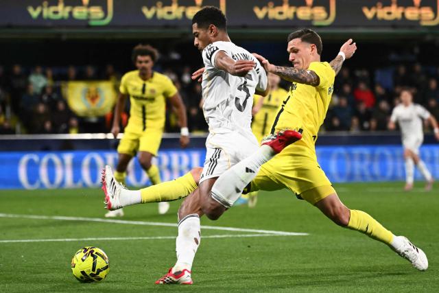Real Madrid's English midfielder #05 Jude Bellingham (L) is challenged by Villarreal's Spanish defender #04 Rafa Marin during the Spanish league football match between Villarreal CF and Real Madrid CF at La Ceramica Stadium in Vila-Real on January 24, 2026. (Photo by JOSE JORDAN / AFP)