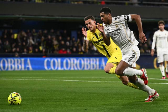 Real Madrid's English midfielder #05 Jude Bellingham (R) runs for the ball with Villarreal's Spanish defender #04 Rafa Marin during the Spanish league football match between Villarreal CF and Real Madrid CF at La Ceramica Stadium in Vila-Real on January 24, 2026. (Photo by JOSE JORDAN / AFP)