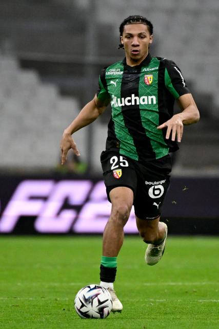 Lens' Burkinabese defender #25 Ismaelo Ganiou runs with the ball during the French L1 football match between Olympique de Marseille (OM) and RC Lens at the Stade Velodrome in Marseille, southern France, on January 24, 2026. (Photo by Miguel MEDINA / AFP)