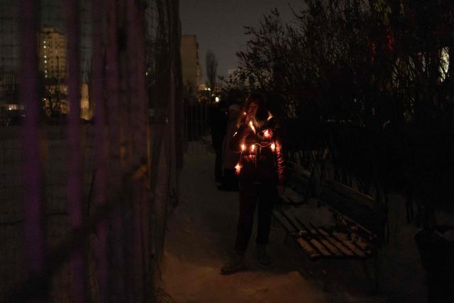 A resident smokes outdoors on a freezing evening during a power outage in a residential neighborhood of Kyiv on January 24, 2026, following Russian missile and drone attacks on Ukrainian energy infrastructure amid the Russian invasion in Ukraine. (Photo by Roman PILIPEY / AFP)
