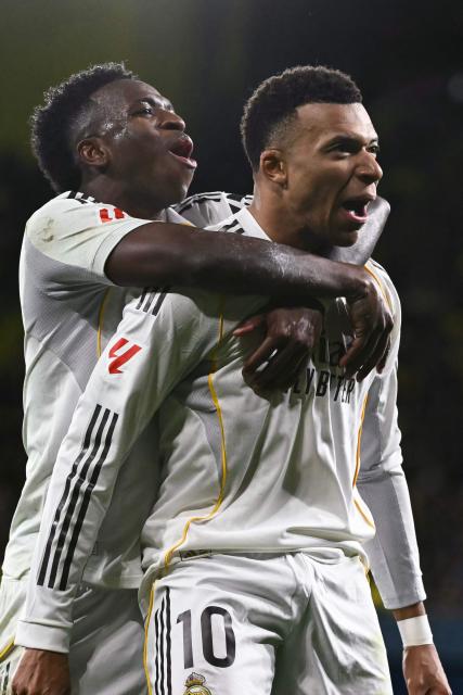 Real Madrid's French forward #10 Kylian Mbappe (R) celebrates with teammate Real Madrid's Brazilian forward #07 Vinicius Junior after scoring his team's second goal from the penalty spot during the Spanish league football match between Villarreal CF and Real Madrid CF at La Ceramica Stadium in Vila-Real on January 24, 2026. (Photo by JOSE JORDAN / AFP)