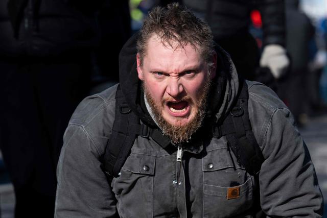 A resident of Minneapolis shouts in anger as he kneels at a makeshift memorial near where a man was shot and killed by federal immigration agents in Minneapolis, Minnesota, on January 24, 2026. Federal immigration agents shot dead a man in Minneapolis on Saturday, officials said -- the second fatal shooting of a civilian in the city, sparking fresh protests and outrage from state officials. The death came less than three weeks after US citizen Renee Good was shot and killed by an Immigration and Customs Enforcement officer involved in sweeps to round up undocumented migrants. (Photo by ROBERTO SCHMIDT / AFP)