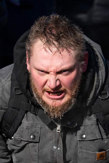 A resident of Minneapolis shouts in anger as he kneels at a makeshift memorial near where a man was shot and killed by federal immigration agents in Minneapolis, Minnesota, on January 24, 2026. Federal immigration agents shot dead a man in Minneapolis on Saturday, officials said -- the second fatal shooting of a civilian in the city, sparking fresh protests and outrage from state officials. The death came less than three weeks after US citizen Renee Good was shot and killed by an Immigration and Customs Enforcement officer involved in sweeps to round up undocumented migrants. (Photo by ROBERTO SCHMIDT / AFP)