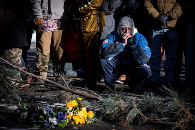 A man pays his respects at a makeshift memorial near where a man was shot and killed by federal immigration agents in Minneapolis, Minnesota, on January 24, 2026. Federal immigration agents shot dead a man in Minneapolis on Saturday, officials said -- the second fatal shooting of a civilian in the city, sparking fresh protests and outrage from state officials. The death came less than three weeks after US citizen Renee Good was shot and killed by an Immigration and Customs Enforcement officer involved in sweeps to round up undocumented migrants. (Photo by ROBERTO SCHMIDT / AFP)