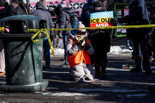 People pay their respects at a makeshift memorial near where a man was shot and killed by federal immigration agents in Minneapolis, Minnesota, on January 24, 2026. Federal immigration agents shot dead a man in Minneapolis on Saturday, officials said -- the second fatal shooting of a civilian in the city, sparking fresh protests and outrage from state officials. The death came less than three weeks after US citizen Renee Good was shot and killed by an Immigration and Customs Enforcement officer involved in sweeps to round up undocumented migrants. (Photo by ROBERTO SCHMIDT / AFP)