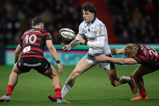 Pau's French wing Grégoire Arfeuil (C) is tackled by Toulouse's French centre Paul Costes (R) during the French Top 14 rugby union match between Stade Toulousain and Section Paloise (Pau) at the Ernest Wallon Stadium in Toulouse, southwestern France, on January 24, 2026. (Photo by Valentine CHAPUIS / AFP)