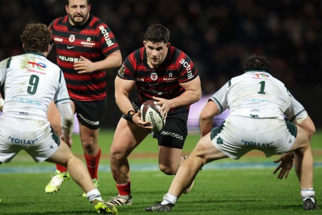 Toulouse's French hooker Julien Marchand (C) is challenged by Pau's French scrum-half Thomas Souverbie (L) and Pau's French prop Alexandre Etchebehere (R) during the French Top 14 rugby union match between Stade Toulousain and Section Paloise (Pau) at the Ernest Wallon Stadium in Toulouse, southwestern France, on January 24, 2026. (Photo by Valentine CHAPUIS / AFP)