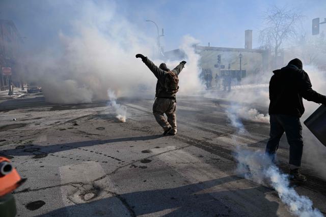 Protesters face a barrage of gas projectiles fired by Minneapolis police officers near where a man was shot dead by federal immigration agents in Minneapolis, Minnesota, on January 24, 2026. Federal immigration agents shot dead a man in Minneapolis on Saturday, officials said -- the second fatal shooting of a civilian in the city, sparking fresh protests and outrage from state officials. The death came less than three weeks after US citizen Renee Good was shot and killed by an Immigration and Customs Enforcement officer involved in sweeps to round up undocumented migrants. (Photo by ROBERTO SCHMIDT / AFP)