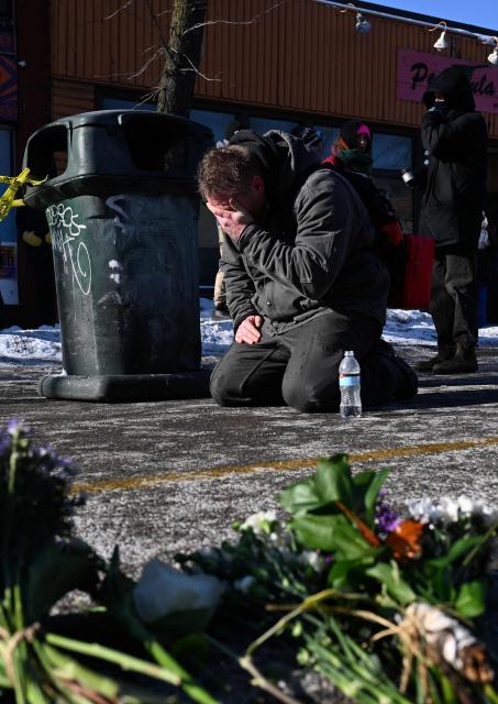 TOPSHOT - A man pays his respects near where a man was shot and killed by federal immigration agents in Minneapolis, Minnesota, on January 24, 2026. Federal immigration agents shot dead a man in Minneapolis on Saturday, officials said -- the second fatal shooting of a civilian in the city, sparking fresh protests and outrage from state officials. The death came less than three weeks after US citizen Renee Good was shot and killed by an Immigration and Customs Enforcement officer involved in sweeps to round up undocumented migrants. (Photo by ROBERTO SCHMIDT / AFP)