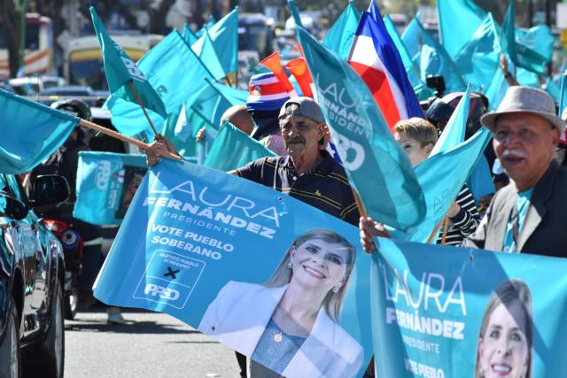 Supporters of Costa Rica's presidential candidate of the Sovereign People party, Laura Fernandez, show banners depicting her during the closing campaign rally at the Colon Avenue in San Jose on January 24, 2026. Right-wing politician Laura Fernandez appears set to win Costa Rica's presidential election in the first round, according to two opinion polls published on January 21. (Photo by Ezequiel BECERRA / AFP)