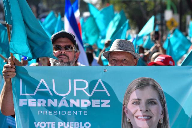 Supporters of Costa Rica's presidential candidate of the Sovereign People party, Laura Fernandez, show a banner depicting her during the closing campaign rally at the Colon Avenue in San Jose on January 24, 2026. Right-wing politician Laura Fernandez appears set to win Costa Rica's presidential election in the first round, according to two opinion polls published on January 21. (Photo by Ezequiel BECERRA / AFP)