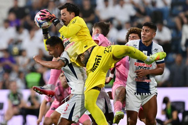 Alianza Lima's Bolivian goalkeeper #23 Guillermo Viscarra grabs the ball as he clashes with teammate defender #06 Renzo Garces during the friendly football match between Peru's Alianza Lima and the US' Inter Miami at the Alejandro Villanueva Stadium in Lima on January 24, 2025. (Photo by Connie FRANCE / AFP)