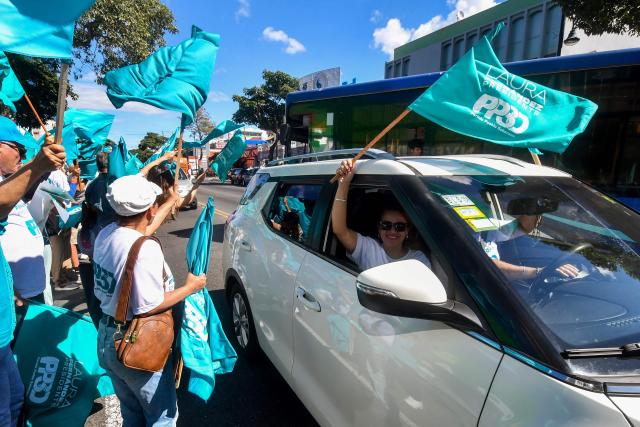 Supporters of Costa Rica's presidential candidate of the Sovereign People party, Laura Fernandez, wave flags during her closing campaign rally at the Colon Avenue in San Jose on January 24, 2026. Right-wing politician Laura Fernandez appears set to win Costa Rica's presidential election in the first round, according to two opinion polls published on January 21. (Photo by Ezequiel BECERRA / AFP)