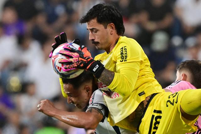 Alianza Lima's Bolivian goalkeeper #23 Guillermo Viscarra grabs the ball as he clashes with teammate defender #06 Renzo Garces during the friendly football match between Peru's Alianza Lima and the US' Inter Miami at the Alejandro Villanueva Stadium in Lima on January 24, 2025. (Photo by Connie FRANCE / AFP)