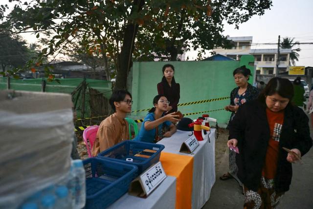 Voters (R) arrive at a polling station for the third and final phase of Myanmar's general election in Yangon on January 25, 2026. (Photo by Sai Aung MAIN / AFP)