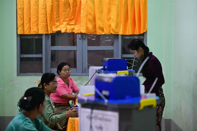 A voter casts her vote at a polling station during the third and final phase of Myanmar's general election in Yangon on January 25, 2026. (Photo by Sai Aung MAIN / AFP)
