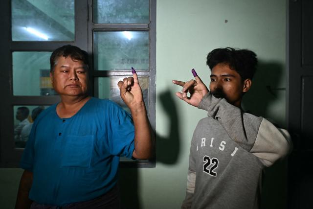 Voters show their inked fingers after casting their ballots at a polling station during the third and final phase of Myanmar's general election in Yangon on January 25, 2026. (Photo by Sai Aung MAIN / AFP)