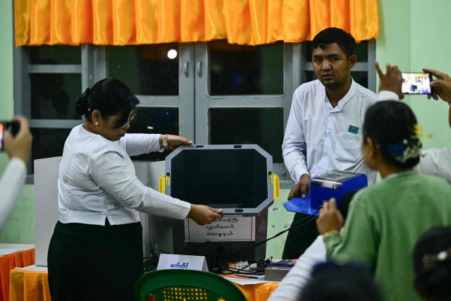 Volunteers from the Union Election Commission (UEC) show an empty ballot box before the opening of polls on the third and final phase of Myanmar's general election, at a polling station in Yangon on January 25, 2026. Myanmar opened the final round of its month-long election on January 25, with the dominant pro-military party on course for a landslide in a junta-run vote critics say will prolong the army's grip on power. (Photo by Sai Aung MAIN / AFP)