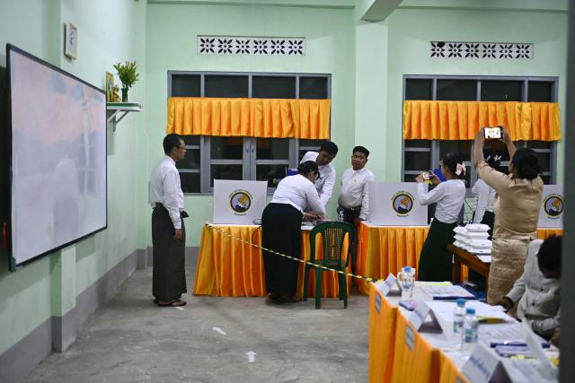 Volunteers from the Union Election Commission (UEC) make final preparations before the opening of polls on the third and final phase of Myanmar's general election, at a polling station in Yangon on January 25, 2026. Myanmar opened the final round of its month-long election on January 25, with the dominant pro-military party on course for a landslide in a junta-run vote critics say will prolong the army's grip on power. (Photo by Sai Aung MAIN / AFP)