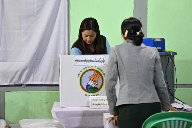 A voter casts her ballot at a polling station during the third and final phase of Myanmar's general election in Mandalay on January 25, 2026. (Photo by Anthony WALLACE / AFP)