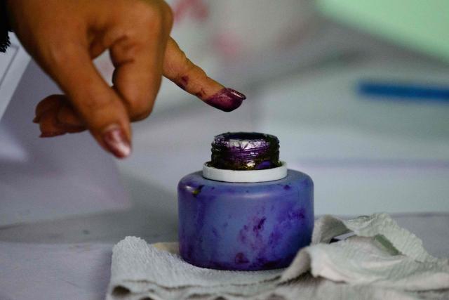 A voter inks her finger after casting her ballot at a polling station during the third and final phase of Myanmar's general election in Mandalay on January 25, 2026. Myanmar opened the final round of its month-long election on January 25, with the dominant pro-military party on course for a landslide in a junta-run vote critics say will prolong the army's grip on power. (Photo by ANTHONY WALLACE / AFP)