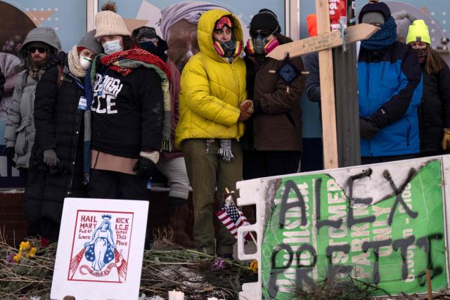 People mourn at a makeshift memorial in the area where 37-year-old Alex Pretti was shot dead by federal immigration agents earlier in the day in Minneapolis, Minnesota, on January 24, 2026. Federal immigration agents shot dead a man in Minneapolis on Saturday, in the second fatal shooting of a civilian during the Trump administration's unprecedented operation in the city, sparking fresh protests and outrage from state officials. The death came less than three weeks after US citizen Renee Good was shot and killed by an ICE officer. (Photo by ROBERTO SCHMIDT / AFP)